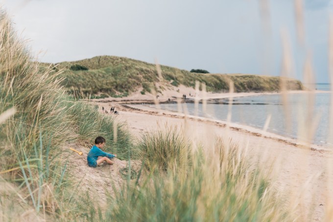 Child on the sand dune at Bamburgh beach